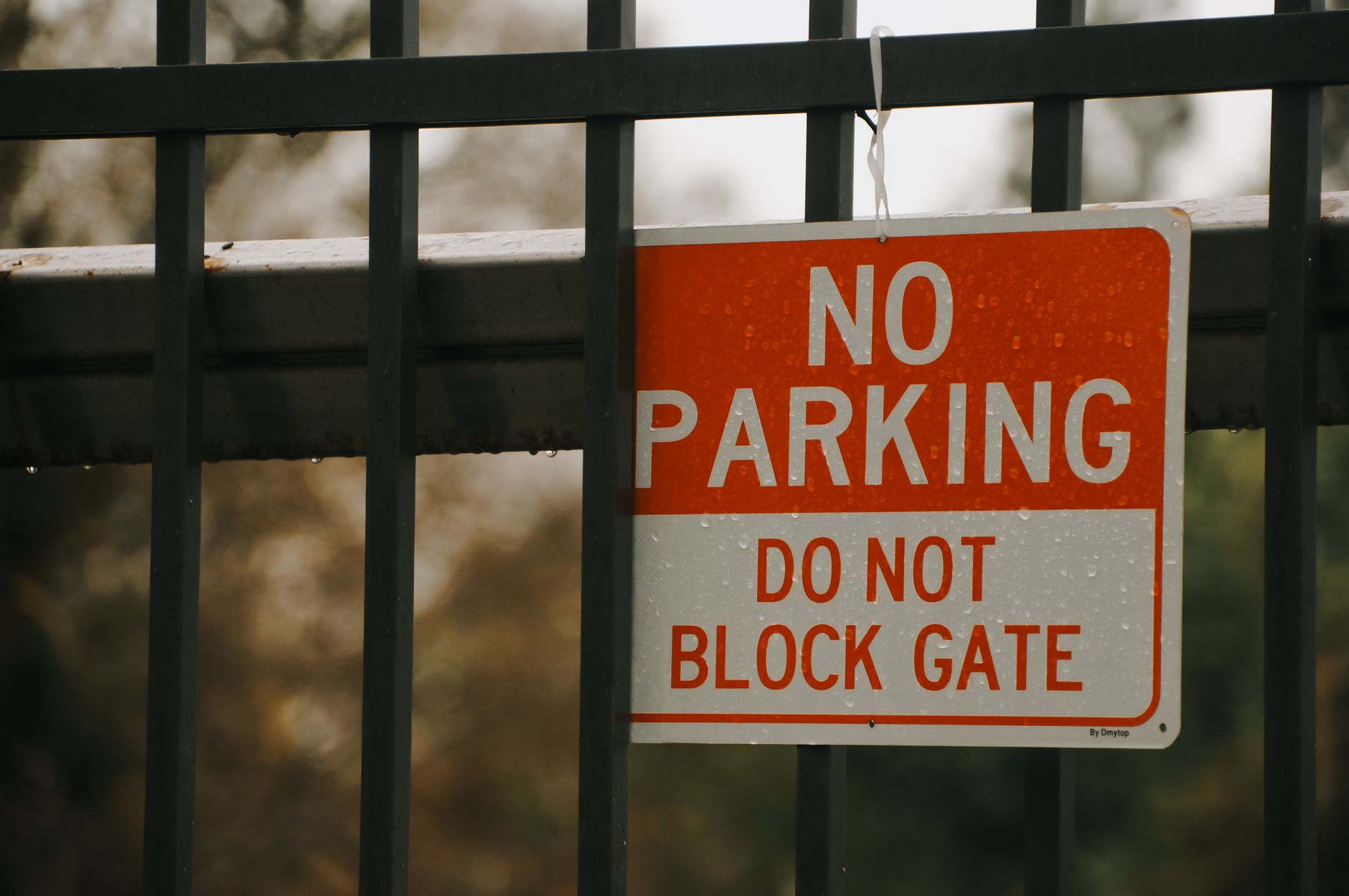 Close-up of a 'No Parking' sign on a metal gate in California City, emphasizing no blocking access in Pearland, TX